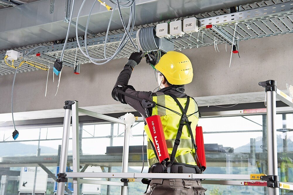 © Hilti/Ottobock
Bei Tätigkeiten über dem Kopf leitet „EXO-O1“ das Gewicht der Arme mittels Seilzugtechnik auf die Hüfte ab. Bei Tätigkeiten über dem Kopf leitet „EXO-O1“ das Gewicht der Arme mittels Seilzugtechnik auf die Hüfte ab.