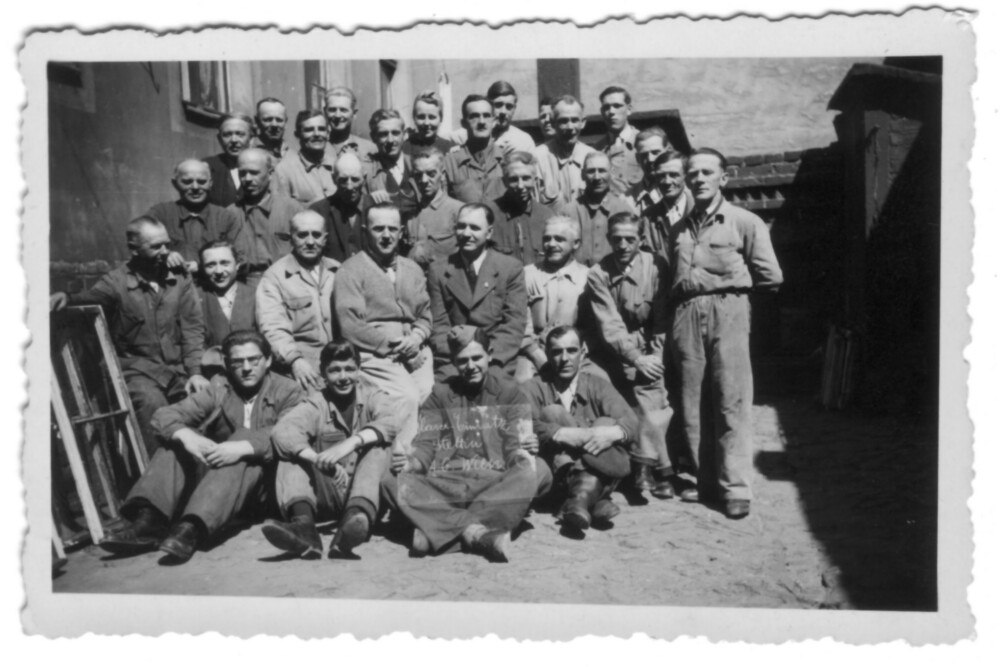 © Archiv Elfriede Zahlner
Gruppenbild des Einsatzes von 31 Wiener Glasern in Stettin. Der junge Mann vorne in der Mitte hält eine Glastafel in der Hand, die Aufschrift lautet „Glaser-Einsatz Stettin A.G. Wien“. Gruppenbild des Einsatzes von 31 Wiener Glasern in Stettin. Der junge Mann vorne in der Mitte hält eine Glastafel in der Hand, die Aufschrift lautet „Glaser-Einsatz Stettin A.G. Wien“.