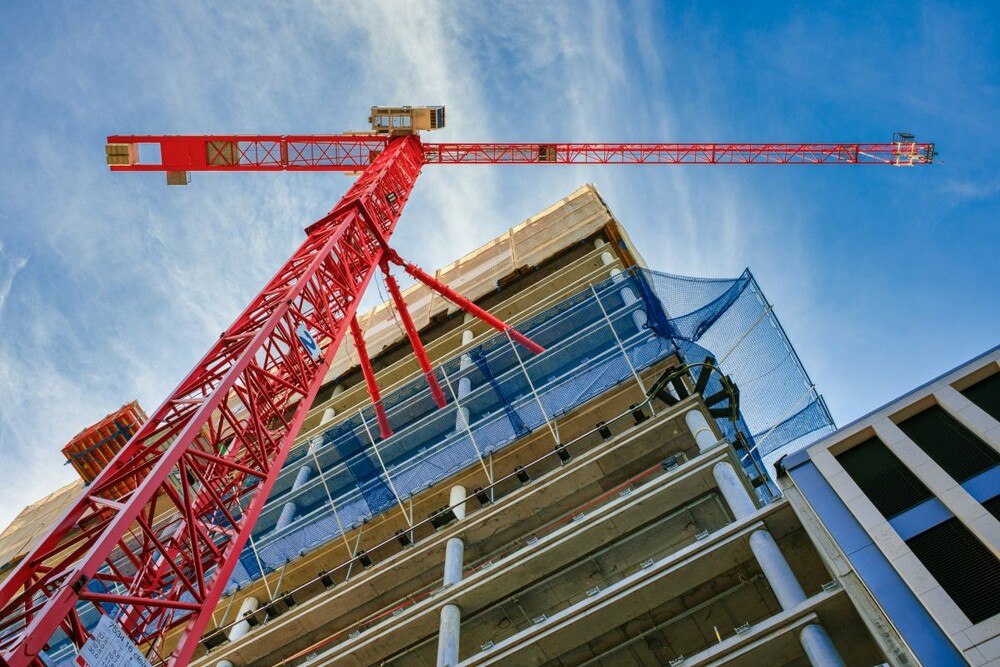 © JARAMA / iStock / Getty Images Plus via Getty Images
Die Bauwirtschaft hat 2021 bei den Produktionswerten in der gesamten DACH-Region zugelegt
Blick von unten auf einen Neubau mit rotem Kran im Vordergrund.