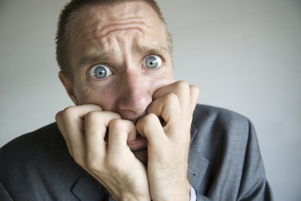 © PeskyMonkey iStock Getty Images Plus Panischer Mann kaut an seinen Fäusten