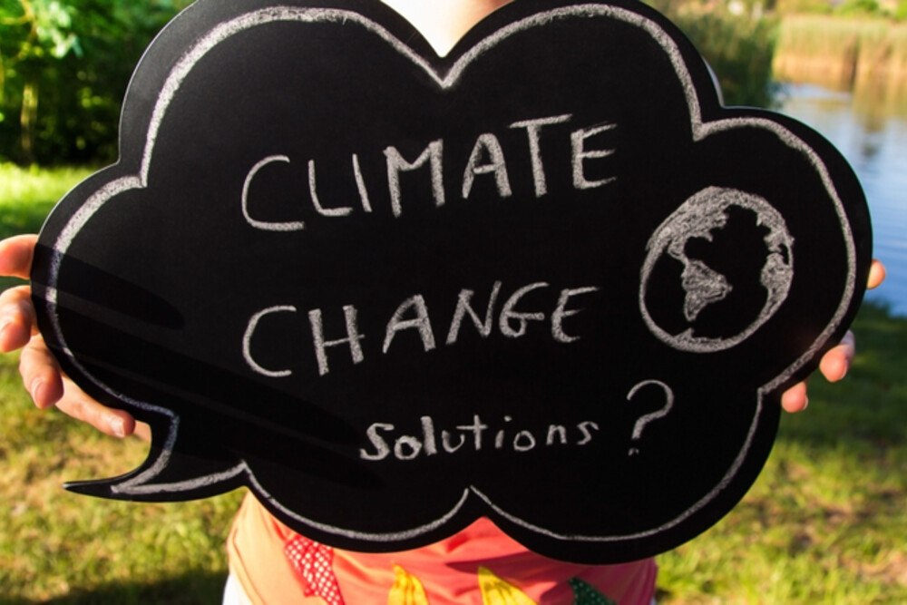 © grechina iStock / Getty Images Plus Tafel mit Aufschrift „Climate Change Solutions?"
