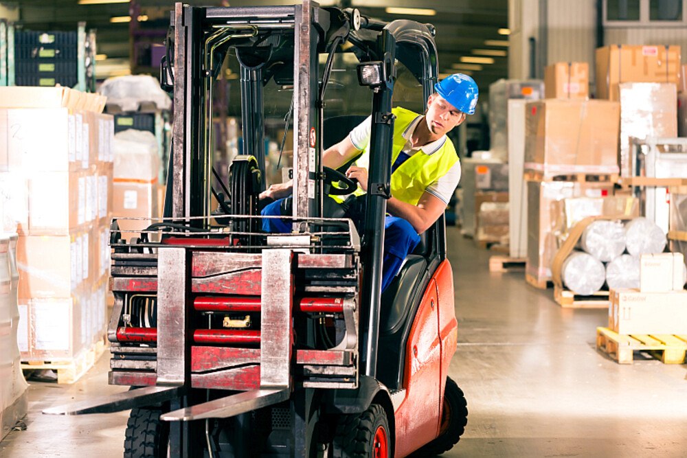 © kzenon istock gettyimages plus Arbeiter im Lager auf Staplerfahrer