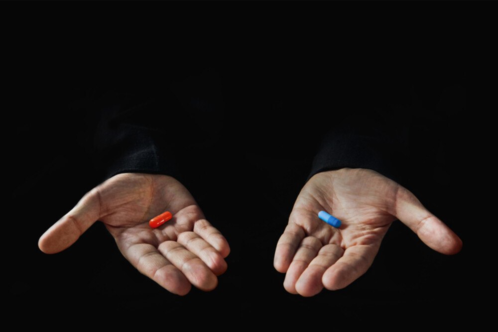 © Diy13 iStock / Getty Images Plus Hände bieten Rote und Blaue Pille