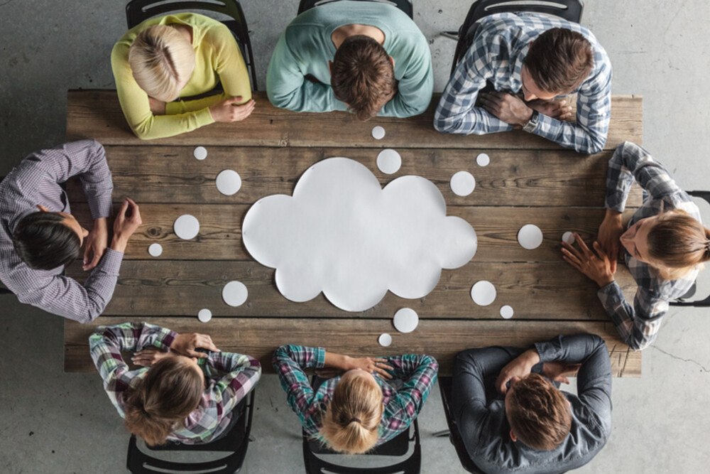 © ALotOfPeople iStock Getty Images Plus Personen sitzen um einen Tisch und denken nach