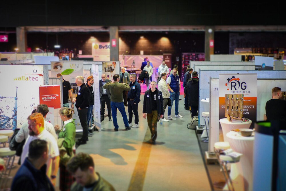 © BvSG e.V.
Nach einem erfolgreichen Event im Frühjahr 2024, freut sich der BvSG auf zahlreiche Besucher*innen bei der Interschank 2025.
Viele Besucher*innen gehen durch eine Messe. Links und rechts stehen einige Banner und Roll-Ups, in der Mitte ein Gang für die Besucher*Innen.