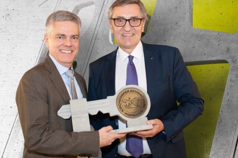 © Kirchdorfer Gruppe
Eine neue Ära bricht an: Der gebürtige Brasilianer Joao Paulo Pereira da Silva übernimmt die Führung des Kirchdorfer Zementwerks von Erich Frommwald.
Zwei Männer halten lächelnd einen großen Schlüssel.