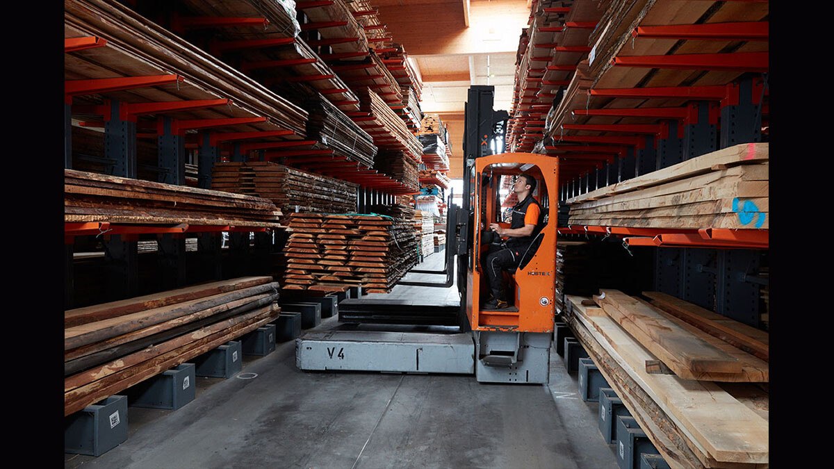 Person transportiert Holz mit Gabelstapler in J. u. A. Frischeis Lagerhalle