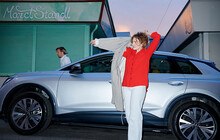 © vibe moves you Eine Frau vor ihrem E-Auto