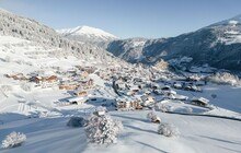© Serfaus-Fiss-Ladis Marketing GmbH / Fabian Schirgi Eine bergige Schneelandschaft mit Hütten.