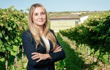 © Weinkellerei Lenz Moser Blonde Frau steht vor Weingut.