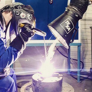 Schweißende Person wird durch Rauchabsaugung geschützt.