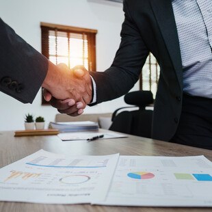 © Worawee Meepian iStock Getty Images Plus Zwei Personen schütteln einander die Hände