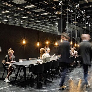 © imm-cologne menschen sitzen an einem schwarz gedeckten Tisch bei der imm-cologne Messe