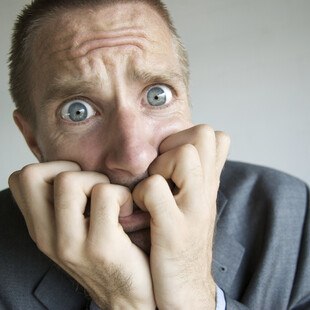 © PeskyMonkey iStock Getty Images Plus Panischer Mann kaut an seinen Fäusten