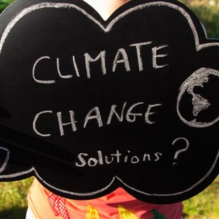© grechina iStock / Getty Images Plus Tafel mit Aufschrift „Climate Change Solutions?"