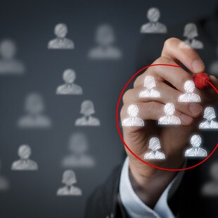 © Jirsak iStock Getty Images Plus Eine Hand zeichnet einen Kreis um stilisierte Köpfe