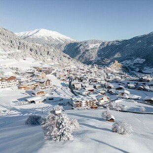 © Serfaus-Fiss-Ladis Marketing GmbH / Fabian Schirgi Eine bergige Schneelandschaft mit Hütten.